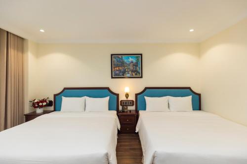 two beds sitting next to each other in a room at CALYSSA HOTELS & VILLAGE in Khu Chi Lăng