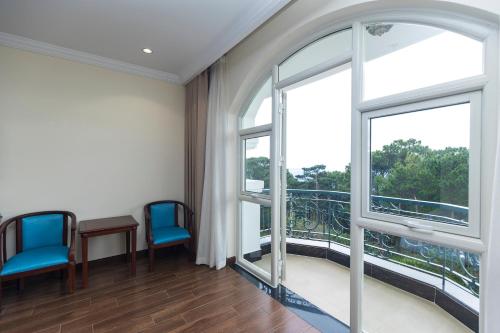 a room with two chairs and two windows at CALYSSA HOTELS & VILLAGE in Khu Chi Lăng