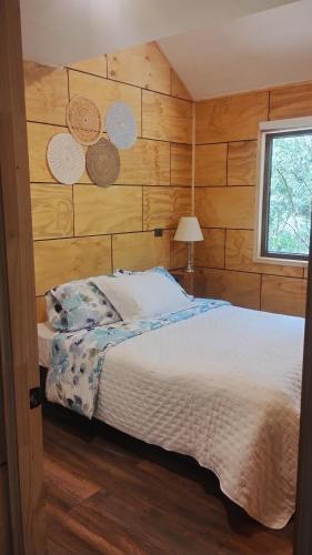 a bedroom with a bed with a wooden wall at Cabaña en molco,entre Villarrica y Pucón in Molco