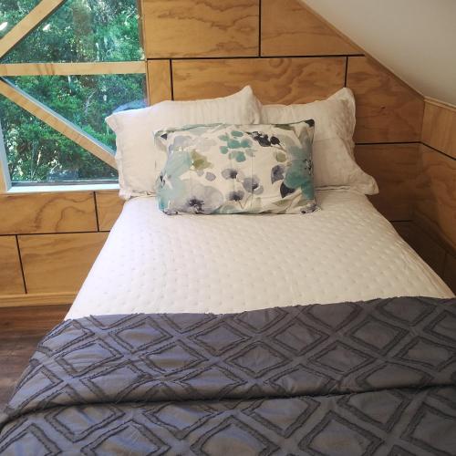 a bed with two pillows on top of it at Cabaña en molco,entre Villarrica y Pucón in Molco