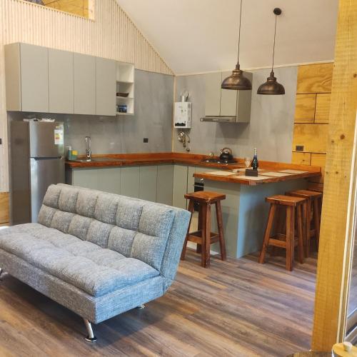 a living room with a couch and a kitchen at Cabaña en molco,entre Villarrica y Pucón in Molco