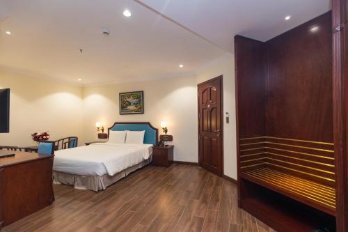 a bedroom with a bed and a desk and a tv at CALYSSA HOTELS & VILLAGE in Khu Chi Lăng
