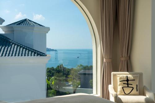 a bedroom with a large window with a view of the ocean at Miyue Shenzhen Blue and White Holy Island Cliff Pool Hotel in Shenzhen