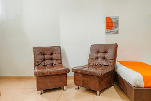 two chairs sitting next to a bed in a room at Hotel Gran Palacio in Pereira