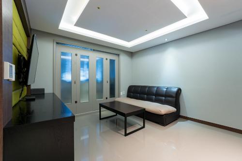 a living room with a couch and a table at Browndot Hotel Incheon Songdo in Incheon
