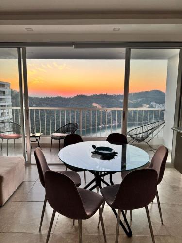 a living room with a table and chairs and a balcony at Apartamento Blue Acapulco Diamante in Acapulco