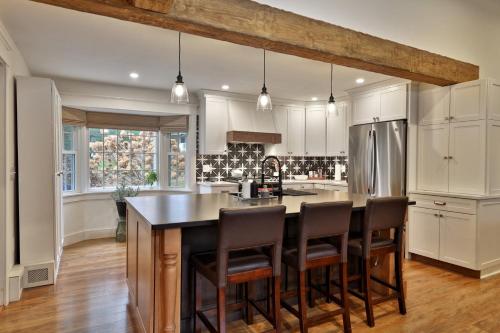 a kitchen with a large island with bar chairs at Susan Lane Hideaway - 4BR, 3BA Renovated Home, Close to Skiing and Town, Fireplace in Rutland