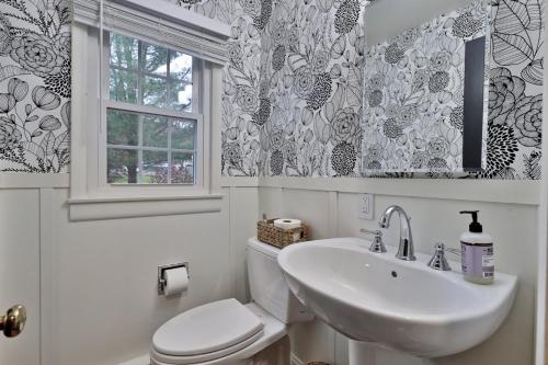 a bathroom with a toilet and a sink and a window at Susan Lane Hideaway - 4BR, 3BA Renovated Home, Close to Skiing and Town, Fireplace in Rutland