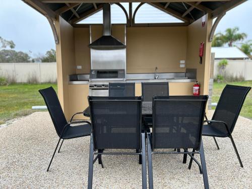 a table and chairs in front of a kitchen at Le Grande Villas Raymond Island in Raymond Island