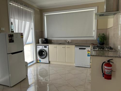 a kitchen with white appliances and a large window at Le Grande Villas Raymond Island in Raymond Island