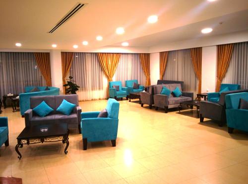 a waiting room with blue chairs and tables at City Inn Palace Hotel in Ramallah