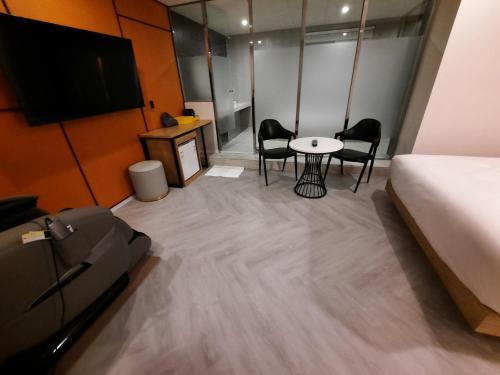 a hotel room with a bed and a table and chairs at Rein Hotel Busan Yeonsan in Busan