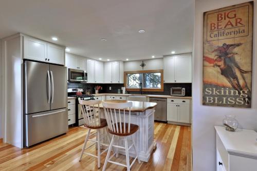 a kitchen with a refrigerator and a table and chairs at Lakeside Lodge at Fern Lake - 3BR, 1BA Waterfront with Dock in Brandon