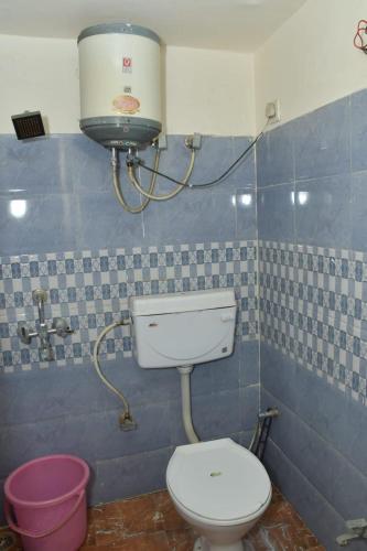 a bathroom with a toilet and a water tank at The Hidden Cove in Bhīm Tāl