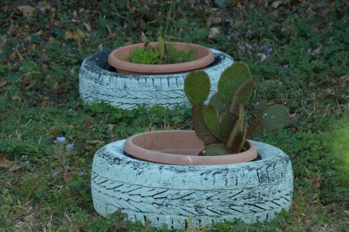 three tires with plants in them on the grass at The Hidden Cove in Bhīm Tāl