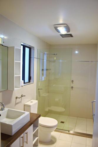 a bathroom with a toilet and a glass shower at Seven On Myrtle at Hat Head - Bring your own linen. in Hat Head