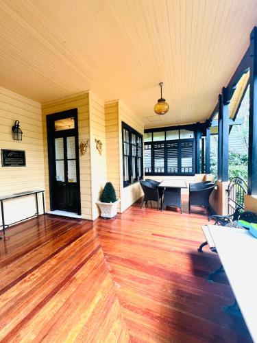 an empty living room with a wooden floor and a table at Leura's Magical Manderley in Leura