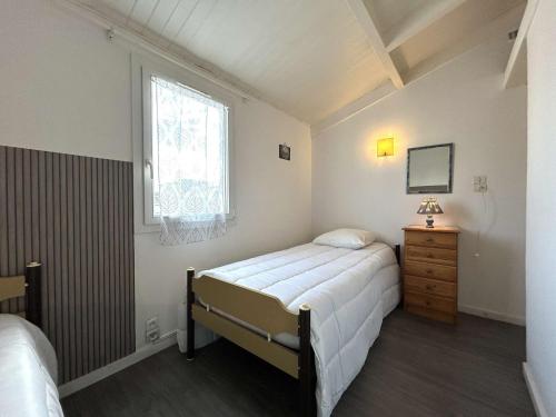 une petite chambre avec un lit et une fenêtre dans l'établissement Maison 3 pièces, piscine chauffée, proche mer - FR-1-224A-71, à Bretignolles-sur-Mer