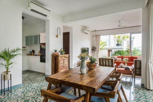 a kitchen and living room with a wooden table at La Olalian 2 & 3 BHK Designer Villas Near Anjuna Beach with Private Pool & Sun Deck & Garden in Anjuna