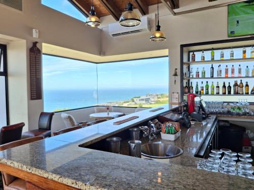 a bar with a view of the ocean at Lakeside Apartment in Oubaai Golf Estate in George