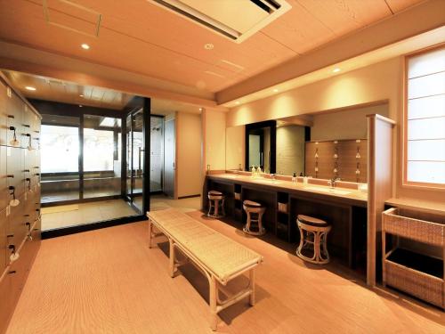 a bathroom with a vanity with stools and a mirror at Hamabeno Ryouriyado Houraikan in Kamaishi