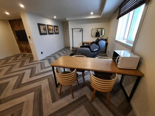 a living room with a table and chairs at Rein Hotel Busan Yeonsan in Busan
