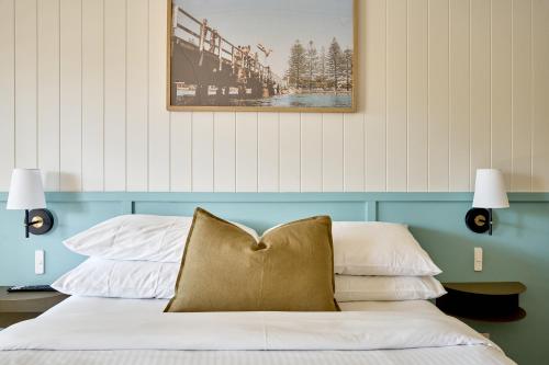 a bedroom with a bed with a blue headboard at Chalet Motel Brunswick Heads in Brunswick Heads