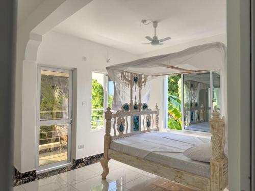 a bedroom with a canopy bed and windows at White House villa in Malindi