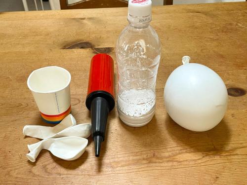 a wooden table with a bottle and a ballinger and an egg at コンテナホテルハコネル in Shirahama