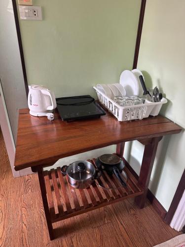 a wooden table with dishes and a laptop on it at Fine Times Resort in Ko Chang
