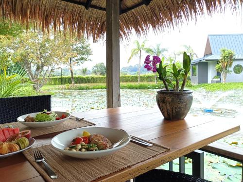 a wooden table with two bowls of food on it at Chombua MaeWang ชมบัว in Chiang Mai