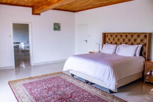 a bedroom with a large bed and a rug at Ashburton Stays in Pietermaritzburg