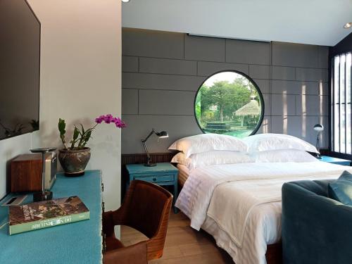 a bedroom with two beds and a round window at Chombua MaeWang ชมบัว in Chiang Mai