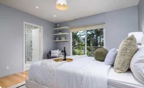 a bedroom with a large white bed and a window at Secluded Luxury Hollywood Hills Retreat in Los Angeles