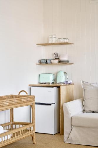a kitchen with a table and a refrigerator and a chair at Chalet Motel Brunswick Heads in Brunswick Heads