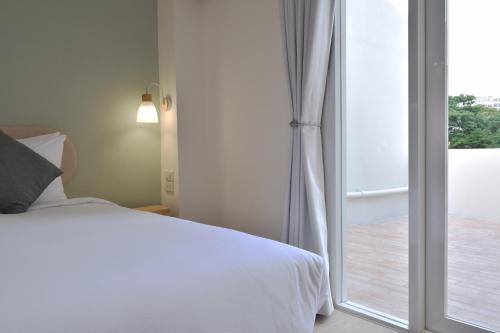 a bedroom with a bed and a sliding glass door at Squirrel House in Bang Rak