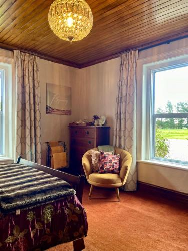 a bedroom with a bed and a chair and a window at 74 on Lockhart in Oturehua