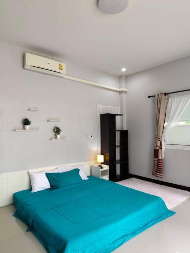 a bedroom with a blue bed and a window at BaanRatsitornHomestay in Langu