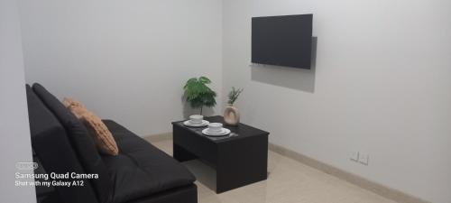 a living room with a black couch and a tv at Southgate Residence, Ellegance in Jakarta