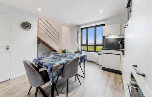 a kitchen and dining room with a table and chairs at Pet Friendly Apartment in Saint-Benoît-des-Ondes