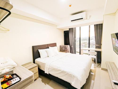 a hotel room with a bed and a window at Lovina 806 at Pollux Meisterstadt in Batam Center