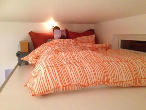 a bed with an orange striped comforter in a bedroom at Private House & Bungalow by the sea in Trondheim