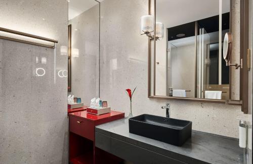 a bathroom with a black sink and a mirror at HUALUXE Shenzhen Bao'an in Shenzhen