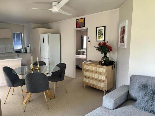 a kitchen and dining room with a glass table and chairs at Central Whangarei Townhouse in Whangarei
