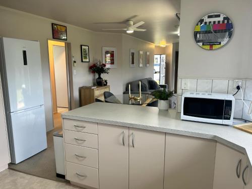 a kitchen with a counter top with a microwave at Central Whangarei Townhouse in Whangarei