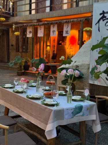 a table with wine glasses and flowers on it at 张家界竹奢民宿 in Zhangjiajie