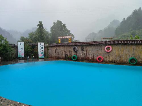 a swimming pool with a train in the background at 张家界竹奢民宿 in Zhangjiajie