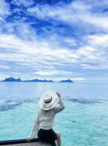 a person wearing a hat sitting in the water at Bubblefish Water Villa in Kampong Bum Bum