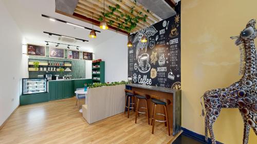a restaurant with a bar with a giraffe on the wall at Wonderla Resort in Kumbalgod
