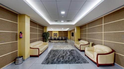 a waiting room with leather chairs and a rug at Wonderla Resort in Kumbalgod